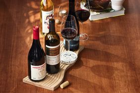 Various bottles of wine and glasses on a wooden table. 