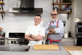 Gavin Kaysen and Andrew Zimmern standing in a kitchen.