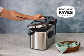 Person lifting lid from Breville BDF500XL Smart Fryer on marble counter