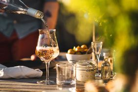 Man pouring up rose wine outdoors