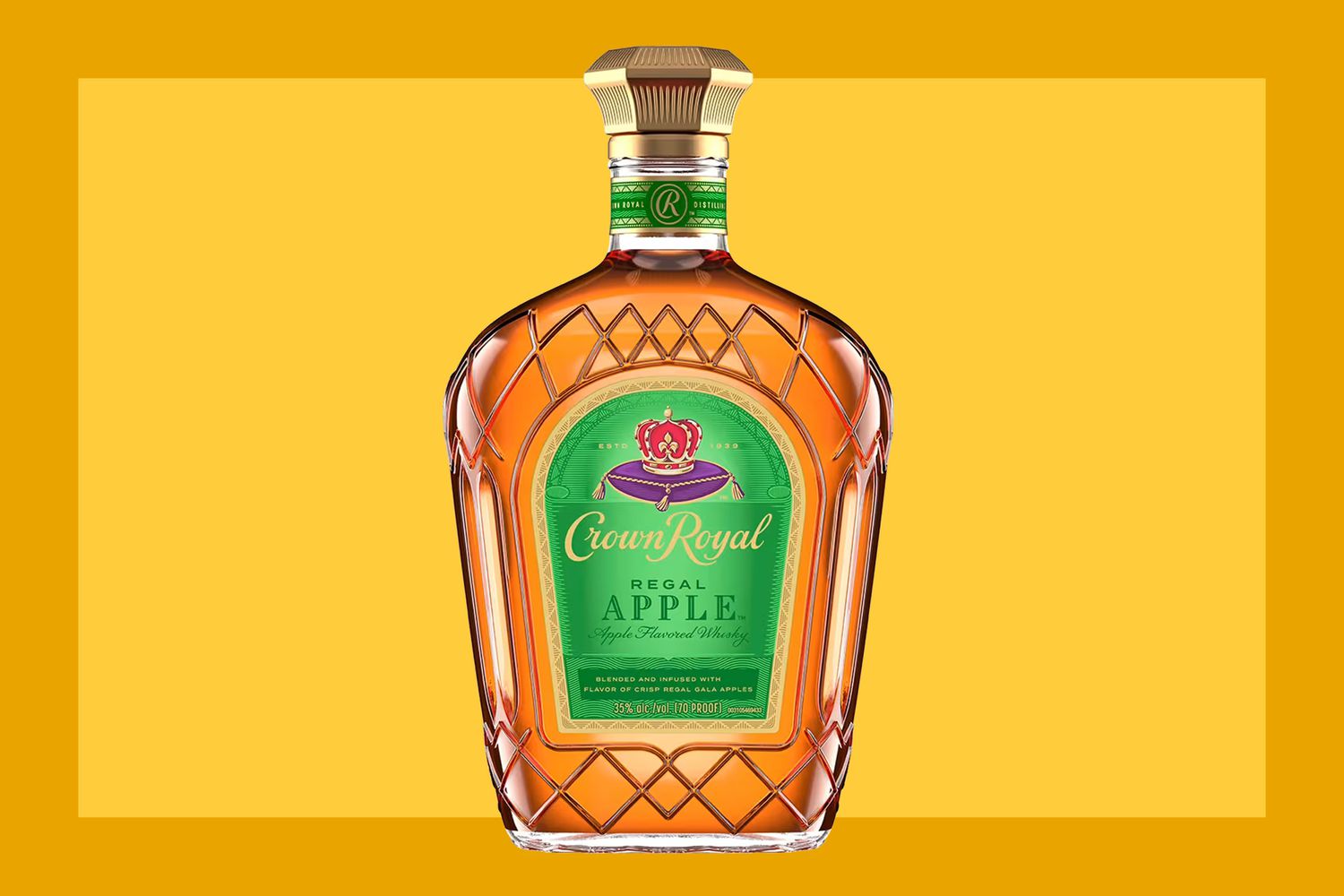 A bottle of Crown Royal Regal Apple on a mustard colored background. 