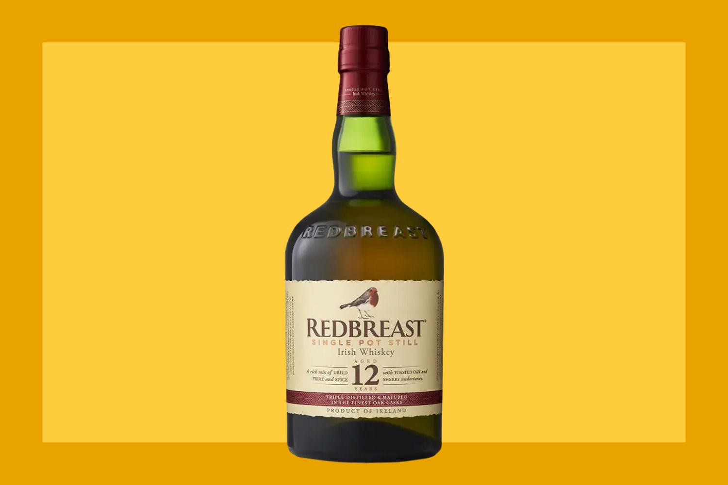 A bottle of Redbreast 12 Year Old on a mustard colored background. 