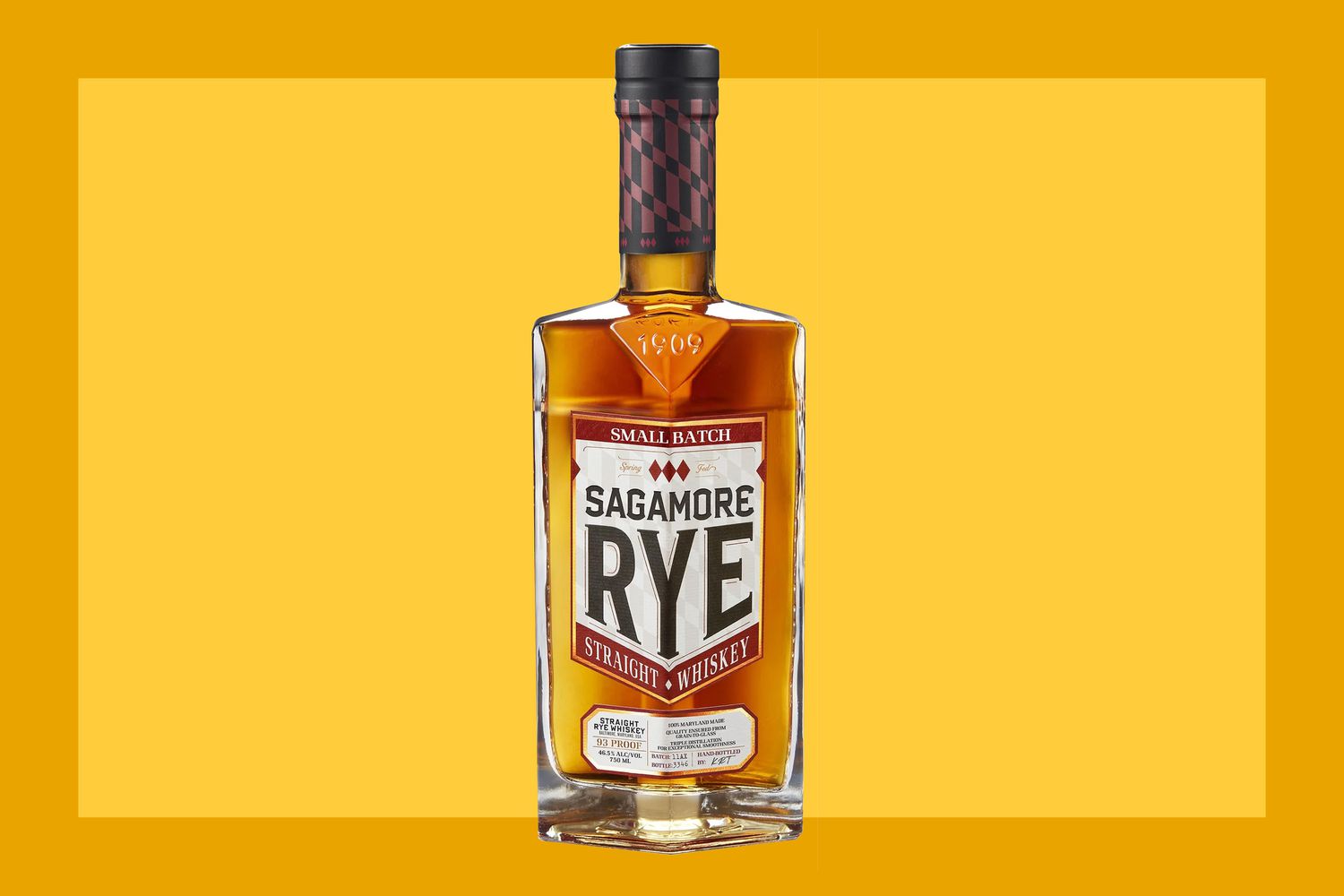 A bottle of Sagamore Spirit Small Batch Rye on a mustard colored background. 