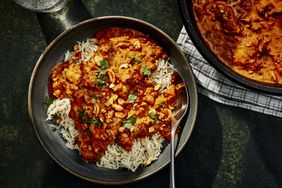 Two bowls of butter chicken with rice.