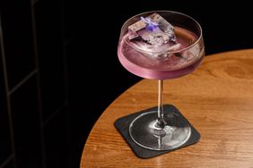 Aviation, drink with gin, lemon juice, maraschino liqueur and violet cream liqueur standing on a bar counter.