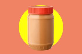 A jar of peanut butter with a red jar lid over a yellow and orange background. 