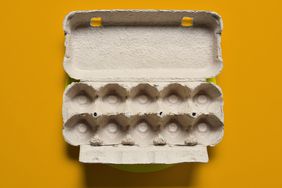 An empty egg carton on a yellow background. 