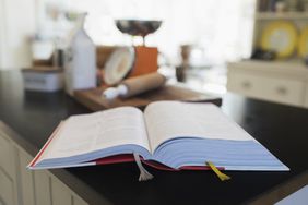 A cookbook open to recipe on a kitchen counter.