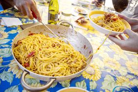 Pasta all'uovo being served to a pasta bowl.