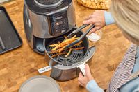 A person removes fries from the Ninja 4-Quart Air Fryer