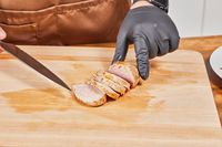 A hand slicing meat cooked in the COSORI TurboBlaze 6.0-Quart Air Fryer