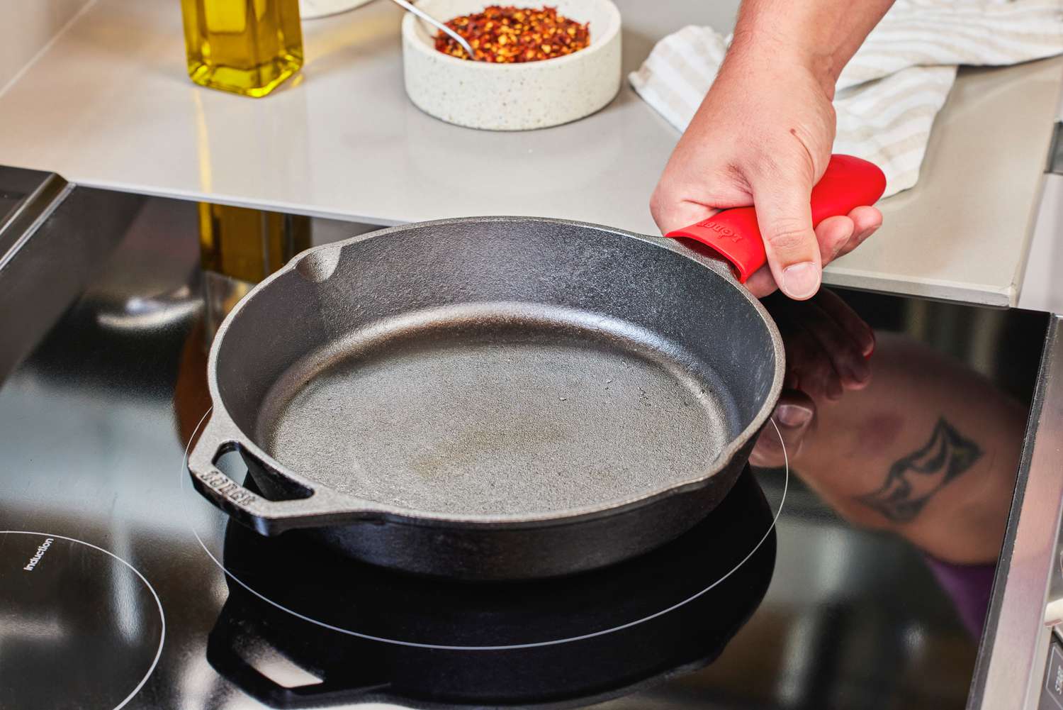 A person places the Lodge Cast Iron Skillet onto a stovetop