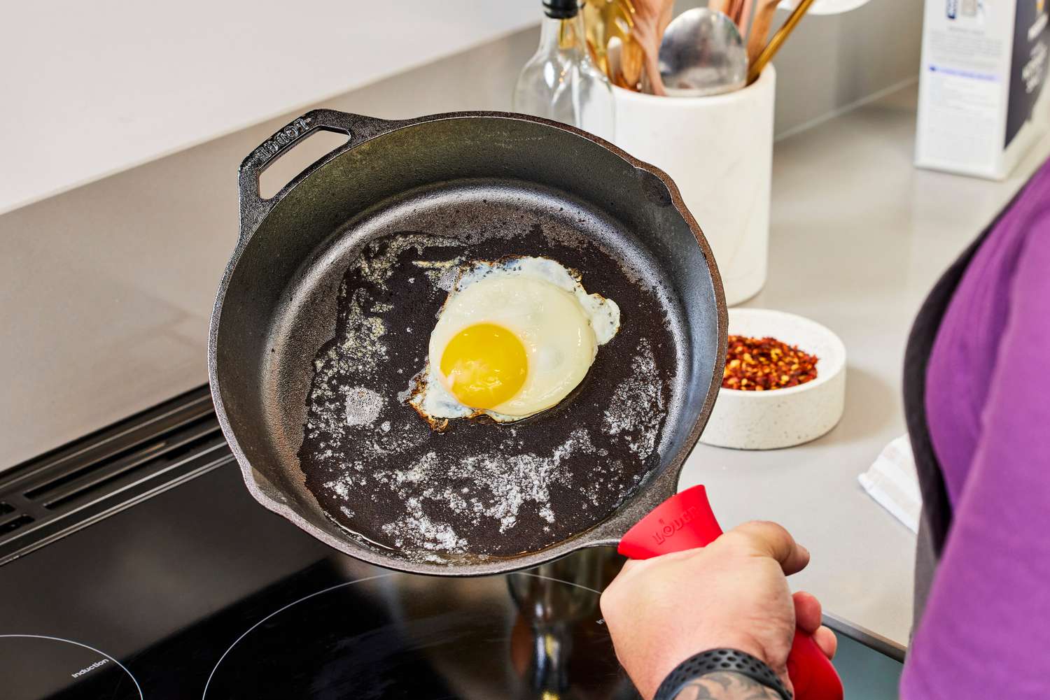 A person cooks an egg in the Lodge Cast Iron Skillet