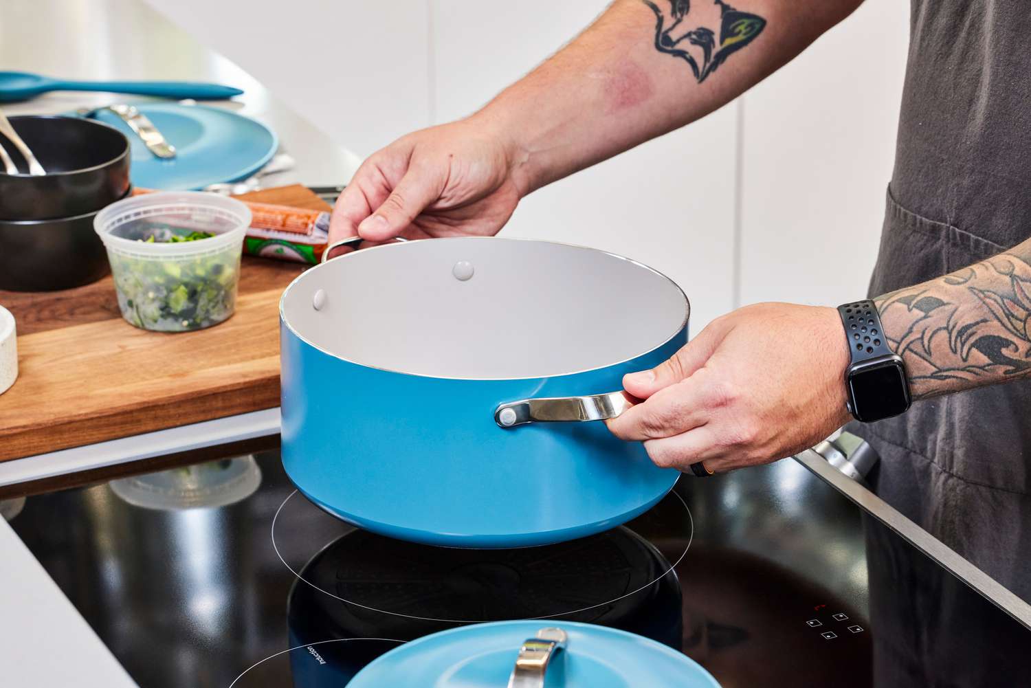 A person places the GreenPan Nova Ceramic Nonstick 10-Piece Cookware Set pot on a stovetop