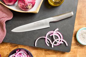 The Global Classic 8-Inch Chef's Knife on a cutting board with sliced onions