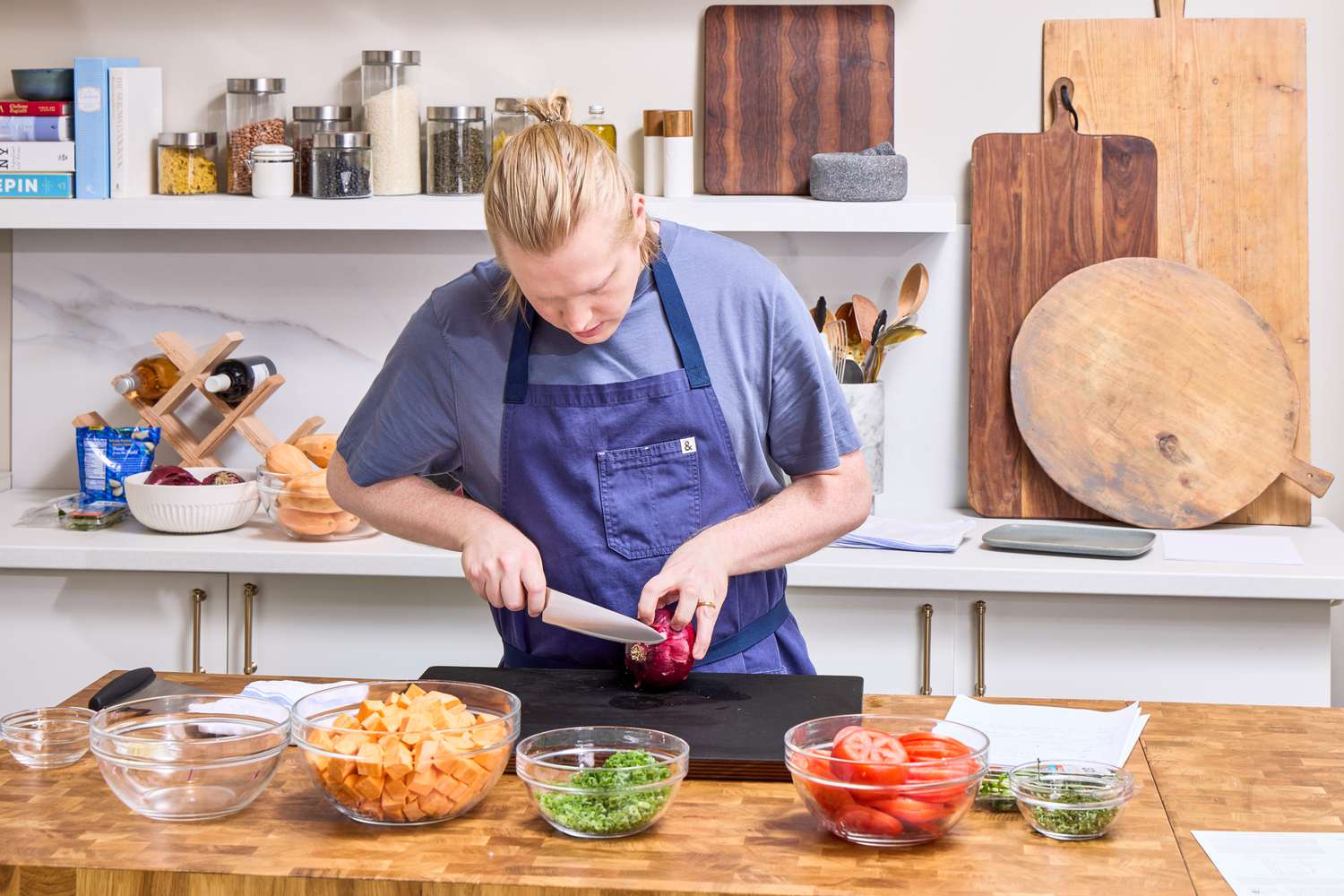 A person slices onion with the Global Classic 8-Inch Chef's Knife in a kitchen