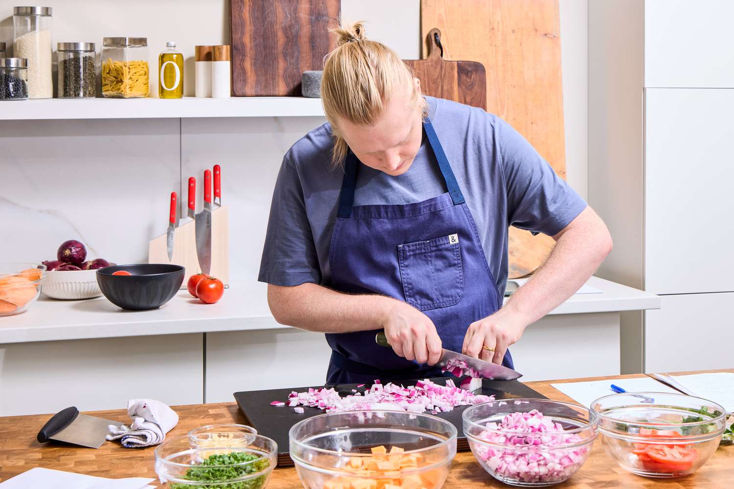 A person chops an onion with the HexClad 8 Inch Damascus Steel Chef’s Knife