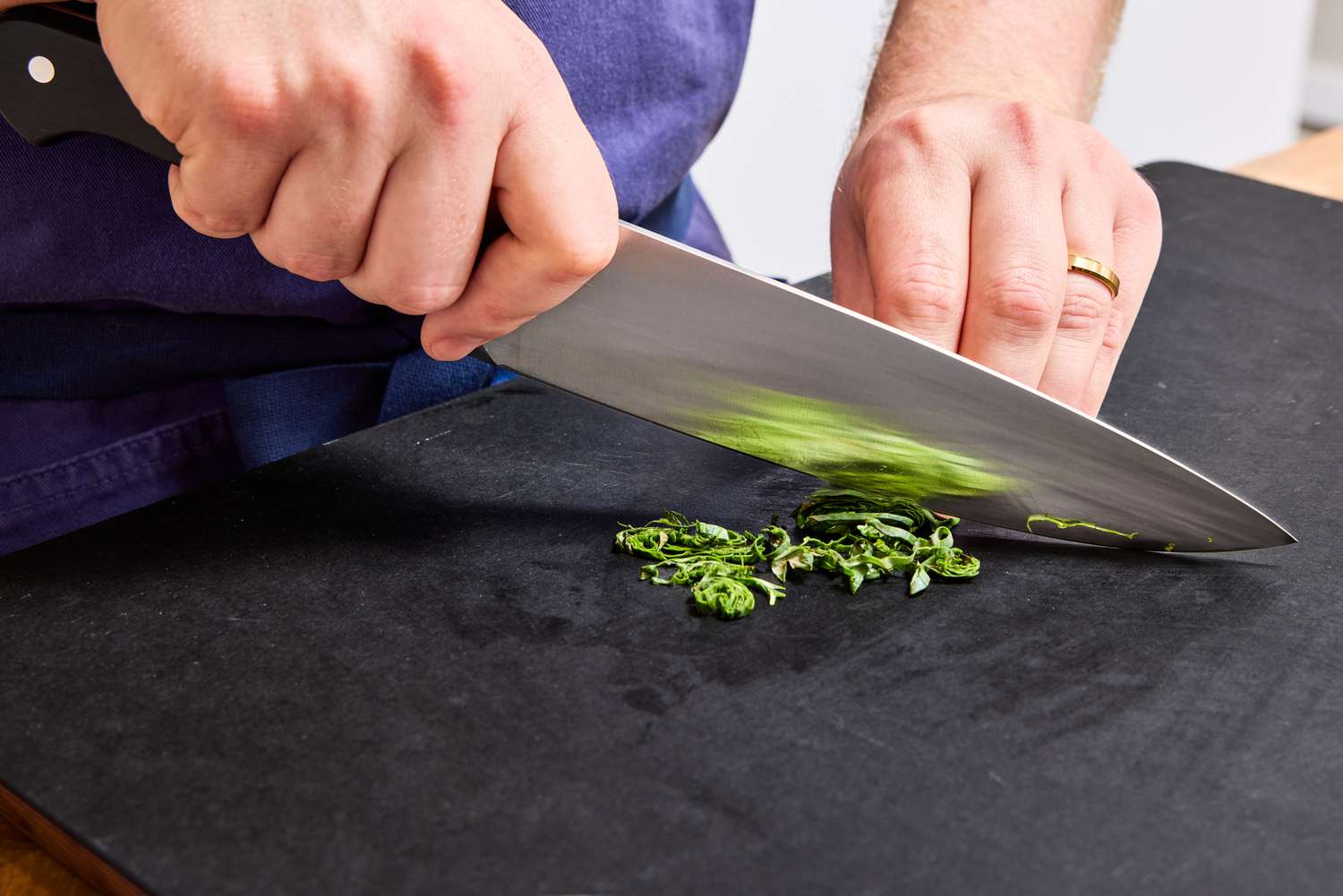 A person chops basil with the Wusthof 8-Inch Classic Chef's Knife