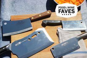 Four cleavers on a cutting board next to a bowl of chopped butternut squash