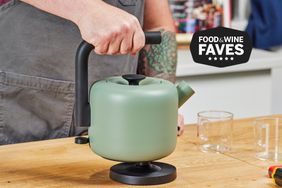 A person picking up the Fellow Electric Kettle