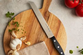 cutting knife on wooden cutting board with fresh herbs