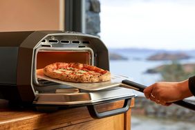 home pizza oven person making a pizza in home oven