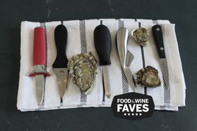 Oyster Knives Laying On A Towel With Oyster Shells