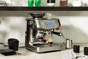 Breville Barista Touch Impress Espresso Machine with Grinder brewing an espresso on a counter