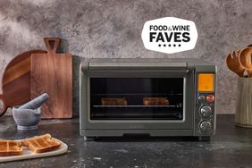 Breville Smart Oven displayed on a black countertop next to kitchen utensils