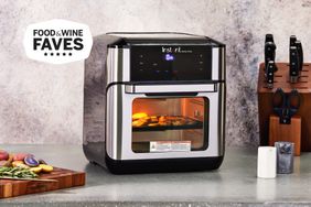 A Instant Pot Vortex Plus 10-Quart 7-in-1 Digital Air Fryer displayed on a countertop next to a block of knives