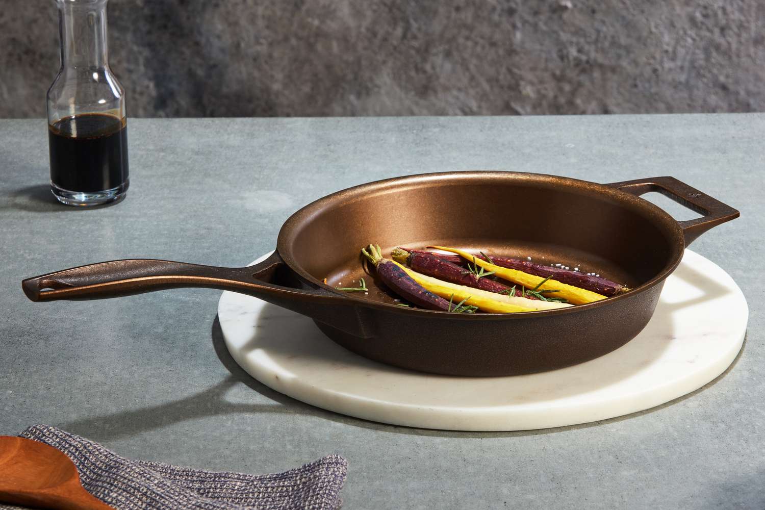 Stargazer 10.5-Inch Cast Iron Skillet displayed on a marble trivet with carrots