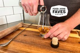 A person pouring whiskey into a Glencairn Crystal Whisky Glass