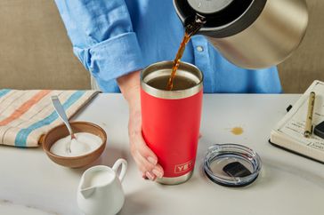 A person pouring coffee into the Yeti Rambler 20 oz Stainless Steel travel mug