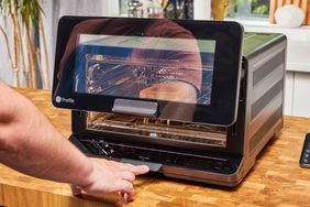 A person pushing the button to open the door of the GE Profile Smart Oven