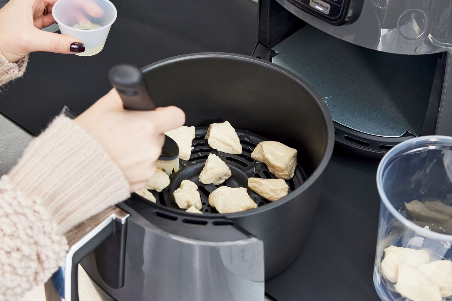 Person preparing chicken in Ninja 4-Quart Air Fryer