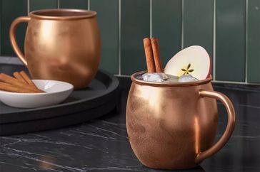 Two Stainless Steel Moscow Mule Mugs with Copper Finish on a kitchen counter