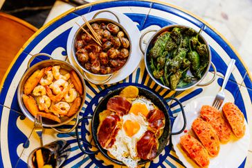 Garlic shrimp (Gambas al Ajillo), Caracoles (Escargot stew), Pimientos de Padro³n (Green fried peppers), Huevos Rotos (Potato with jamon and fried egg) and tomato bread