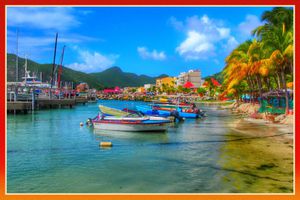 Colorful boats, palm trees, and a mountain backdrop showing St Maarten