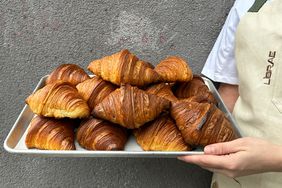 A baker holding a tray of croissants from Librae bakery