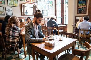 A person sits alone waiting for their party in a restaurant