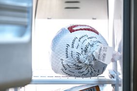 A frozen turkey on a freezer shelf. 