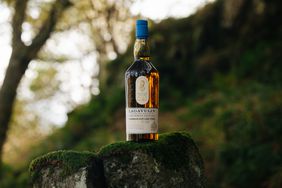 Lagavulin Offerman Edition: Caribbean Rum Cask Finish Aged 11 Years on a moss covered rock.