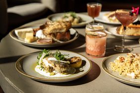 A table with plates of food and cocktails at Plough in Lancaster, PA.