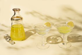 A small decanter of limoncello and two glasses. 