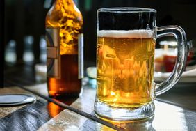 A beer mug and bottle on an outdoor table.