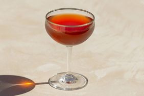 Newark cocktail in coupe glass with a shadow against a cream background.