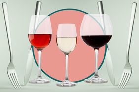 Three glasses of wine in front of a background of knives and forks with peach and green.