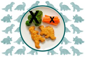 A plate with dinosaur shaped chicken nuggets, broccoli and carrot sticks over a background of green dinosaur nuggets. 