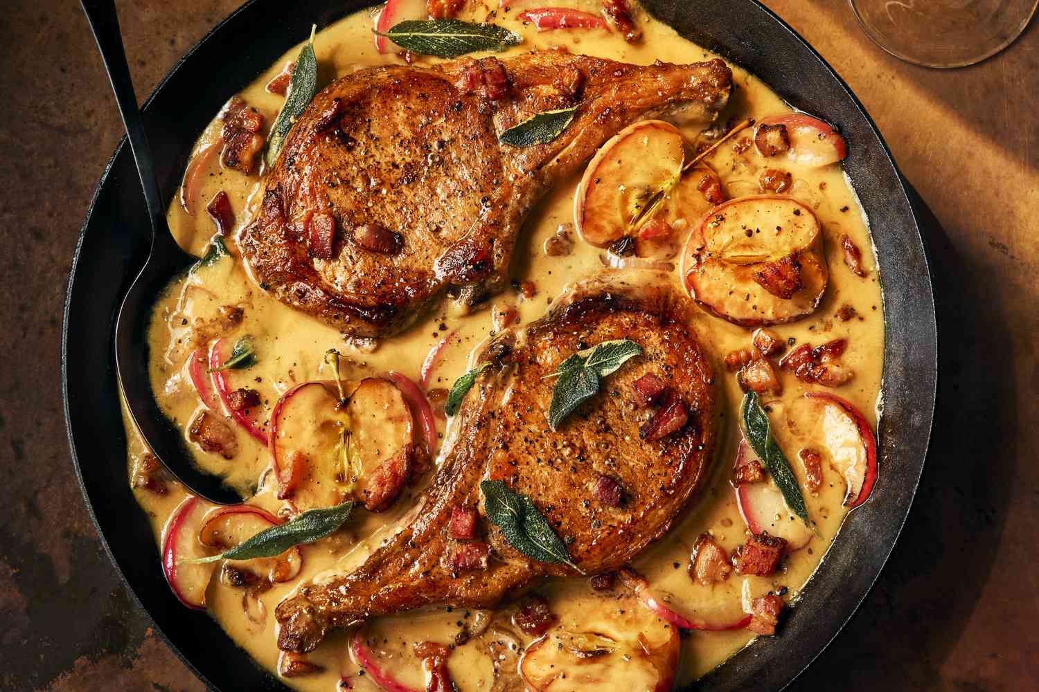 Pork Chops with Apples and Bacon in a cast iron skillet