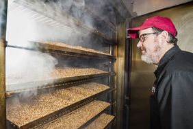 Curtis Holmes, Plant Director of Alaskan Brewing Company, opening the door to the smoked malt in their smokehouse.